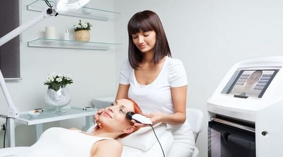 a specialist performs a skin rejuvenation session with a device